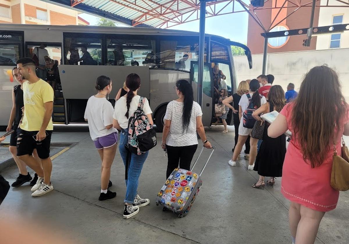 Viajeros se disponen a tomar un autobús en la estación.