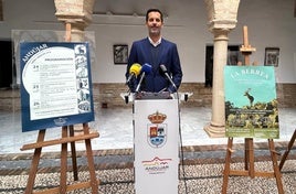 JUAN CARLOS MARTÍNEZ POSA CON LOS CARTELES DE LAS ACTIVIDADES.