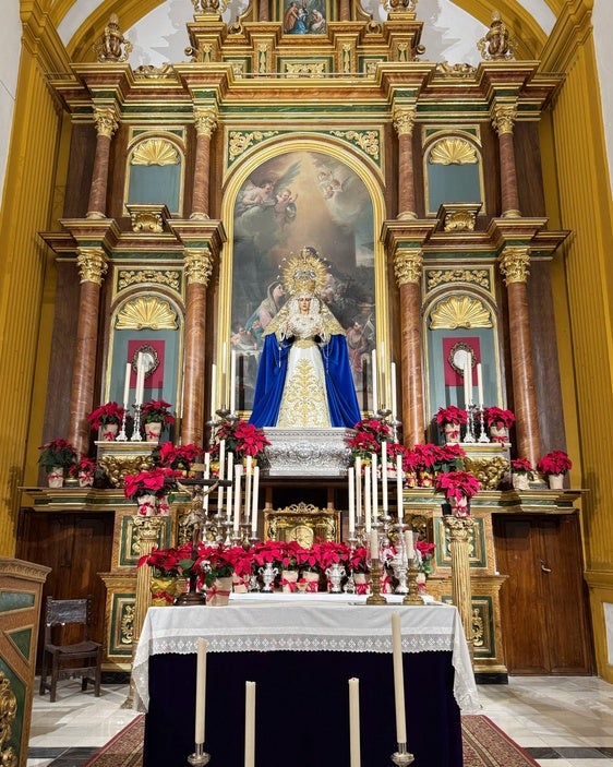 Los pascueros navideños adornan la imagen de la Virgen.