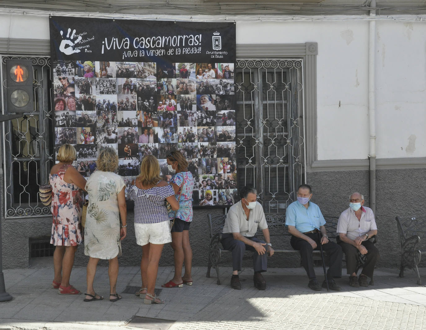 Un mural con fotos de otros Cascamorras en una calle de Baza.