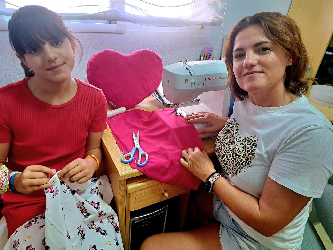 Belén Fernández junto a su hija practicando para preparar los cojines terapéuticos.