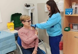 Una enfermera realiza una inyección a una paciente en un centro de salud.