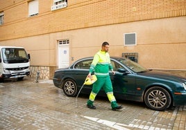 Un operario elimina los restos de sangre de la calzada