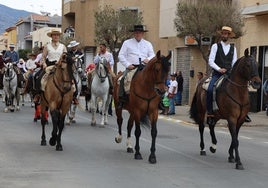 Tres jinetes pasean con sus caballos por una calle de El Ejido.