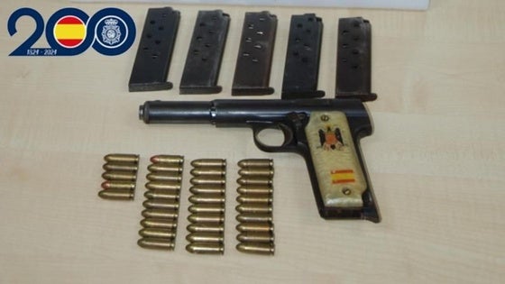 Viajaba en el coche con tres menores y un arma lista para disparar con símbolos preconstitucionales