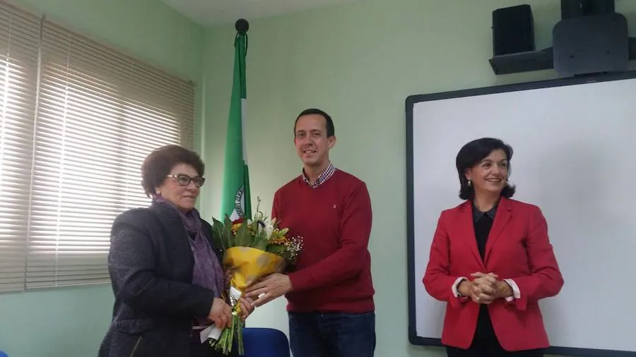 El delegado de Salud entrega un ramo de flores a la presidenta de Vivir, junto a la directora del Distrito Sanitario Poniente. 