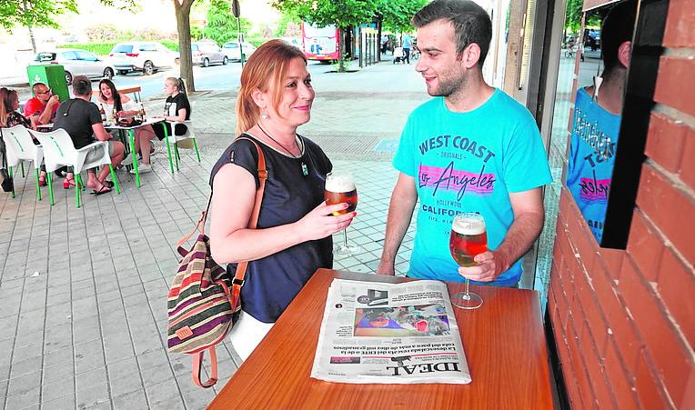 Dos clientes se disponen a leer IDEAL en una terraza.