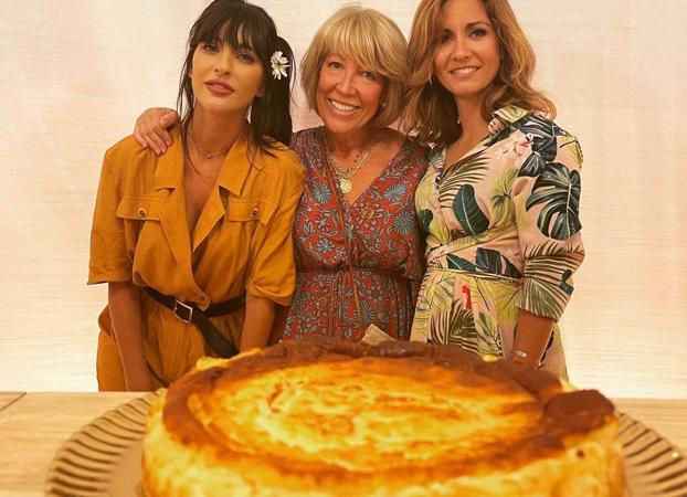 Pilar Molina junto a sus hijas y una tarta de queso. 
