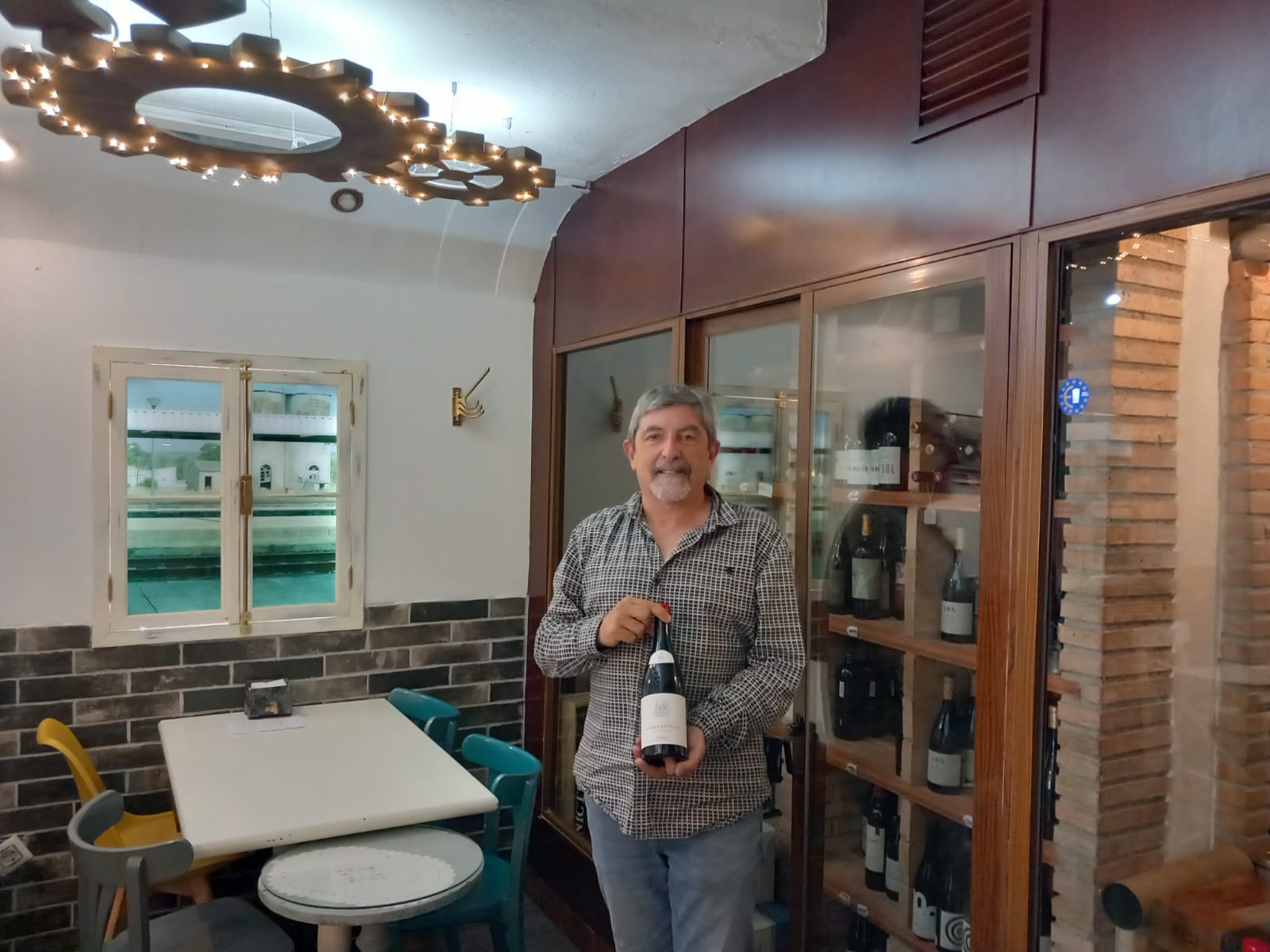 El sumiller David Rodríguez en una taberna de Úbeda junto a una botella de vino.