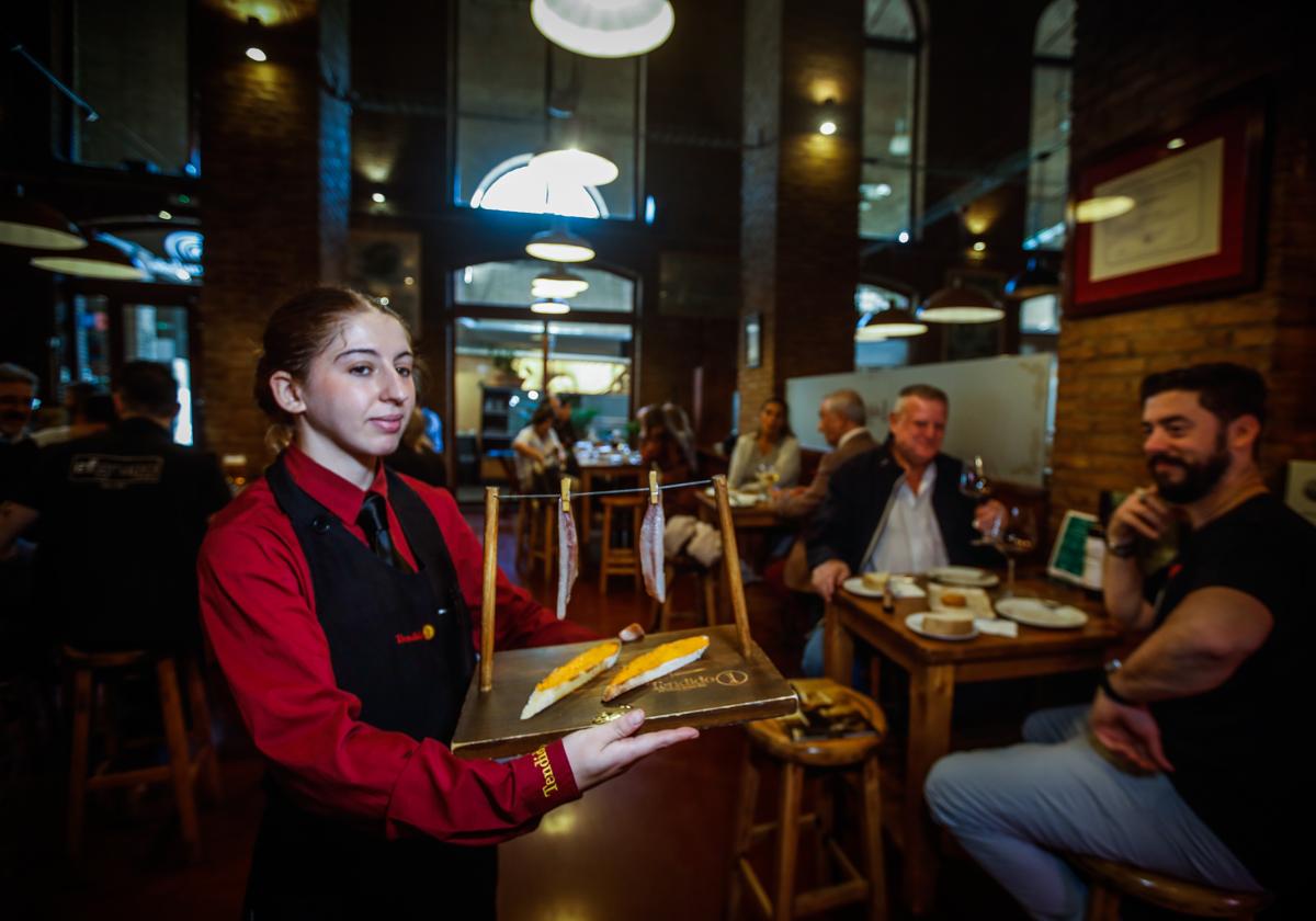 Una camarera de Tendido 1 sirve un aperitivo.