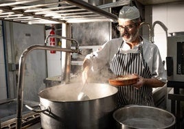 El jefe de cocina del Restaurante Chikito se afana con un gran perol con la Olla de San Antón.