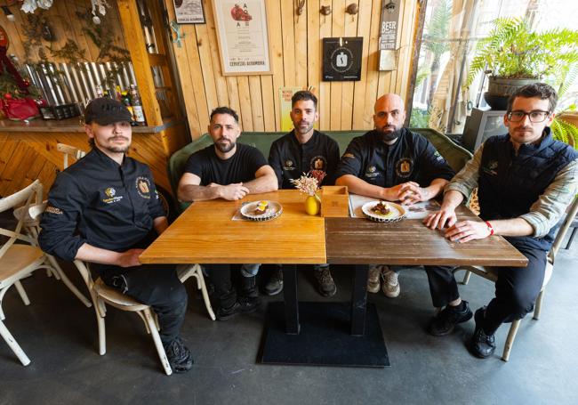 Equipo de cocina y sala de Garden Plaza sentado a una de las mesas del luminoso establecimiento.