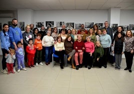 Paco López, sentado en el centro, rodeado de vecinos y vecinas que han participado en la colección de fotografías 'Al natural'.