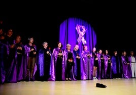 Las participantes, con túnicas moradas y rosas rojas.