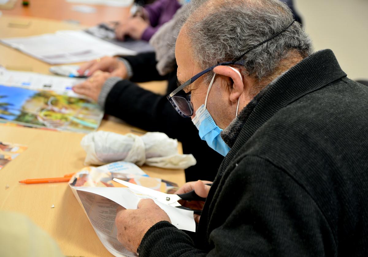 Personas mayores realizan manualidades en el Centro Social La Nava con 'Envejecimiento activo'.