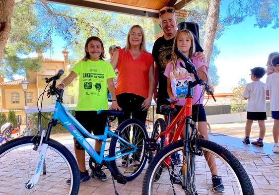 La concejala de Fiestas y el alcalde, con los agraciados con las dos bicicletas sorteadas en el Parque de los Pinos.