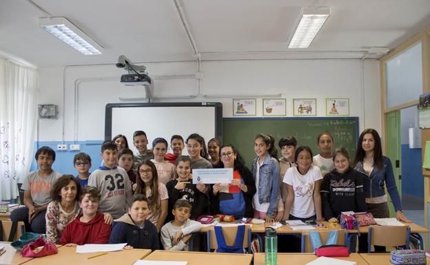 Los estudiantes y la concejala de Educación carbonera posan con el cheque entregado.