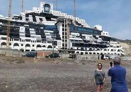 Un mujer se hace una fotografía delante de El Algarrobico.