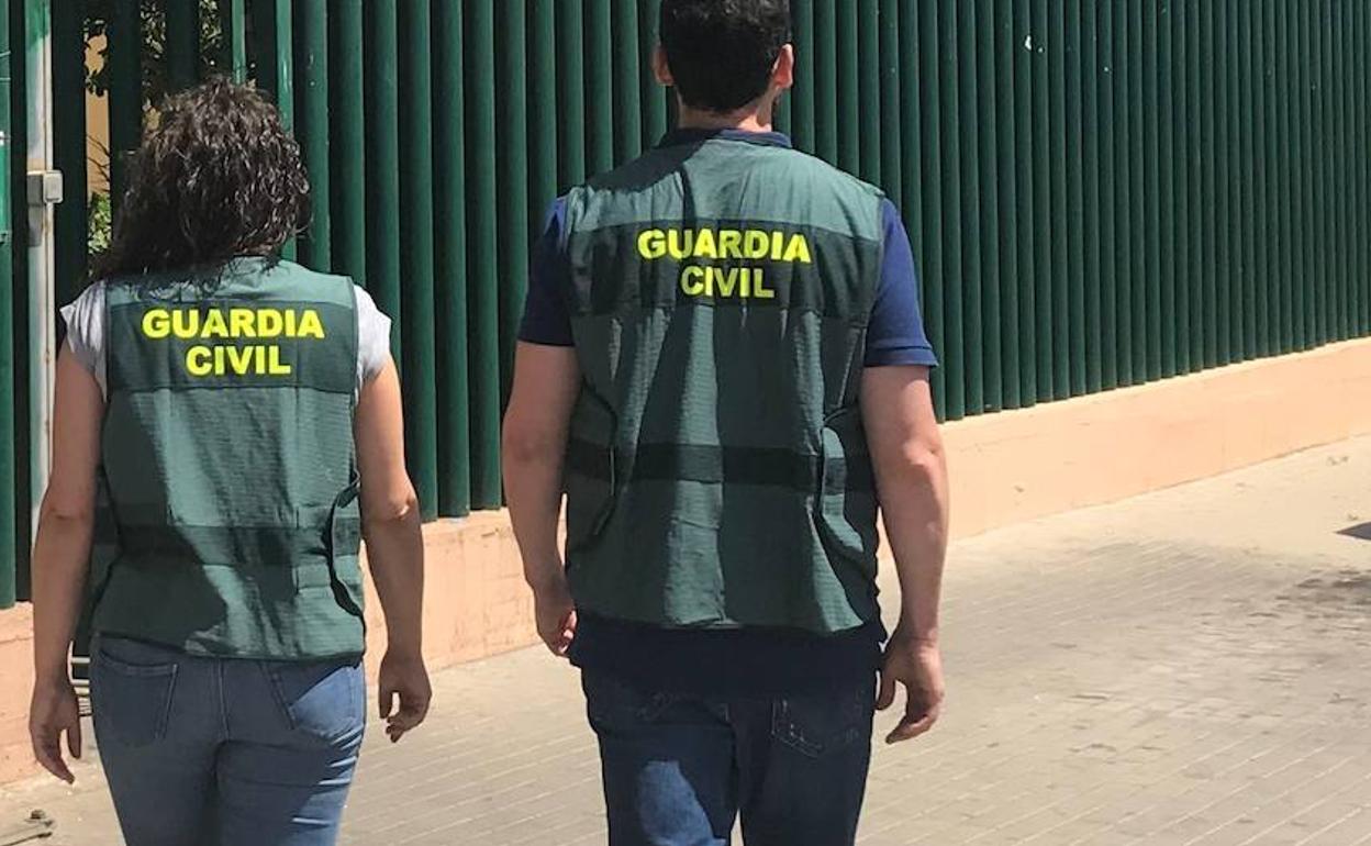 Dos agentes de la Guardia Civil se dirigen a las instalaciones de un cuartel. 