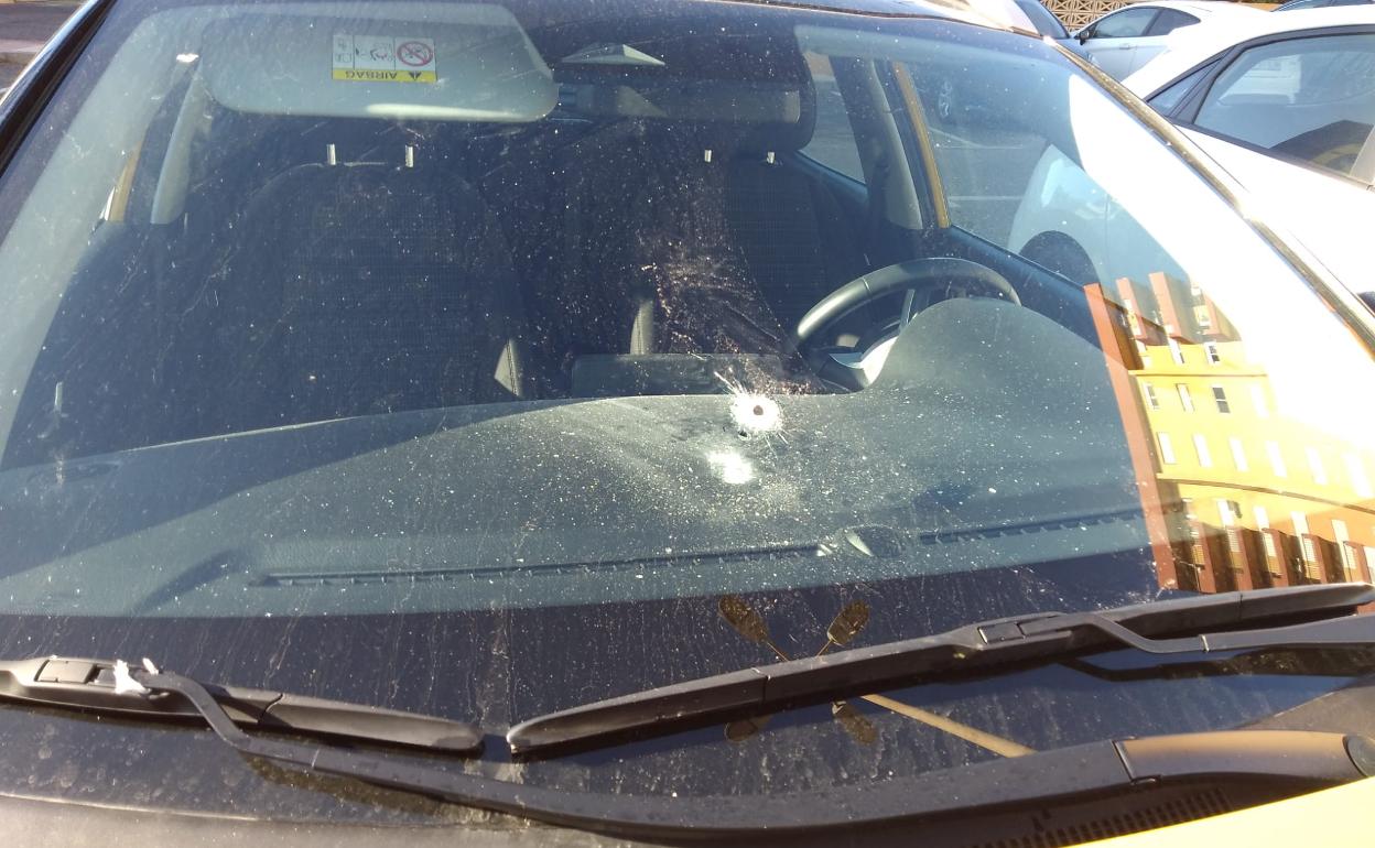 Así ha quedado la luna de un vehículo estacionado en el lugar de los hechos.