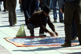 Un vendedor ambulante despliega una manta con discos de música y otros productos.