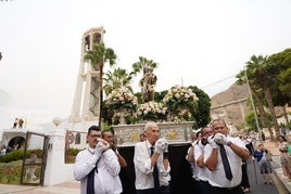 Varios costaleros demuestran su devoción llevando a la Virgen