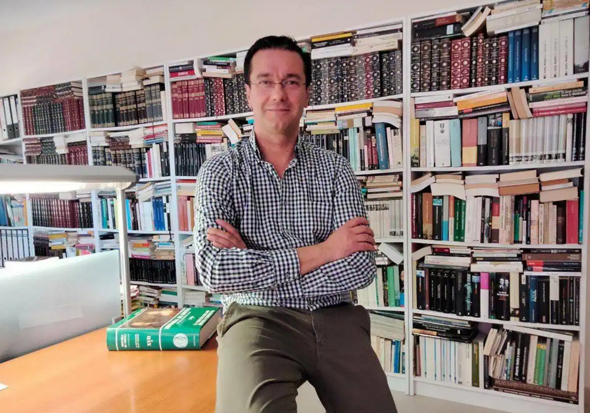 Raúl Pomares en una sala rodeado de libros.