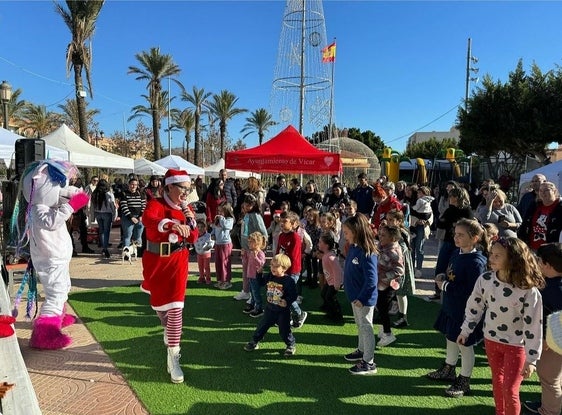 Varios niños siguen a una mamá Noel en el municipio de Vícar.