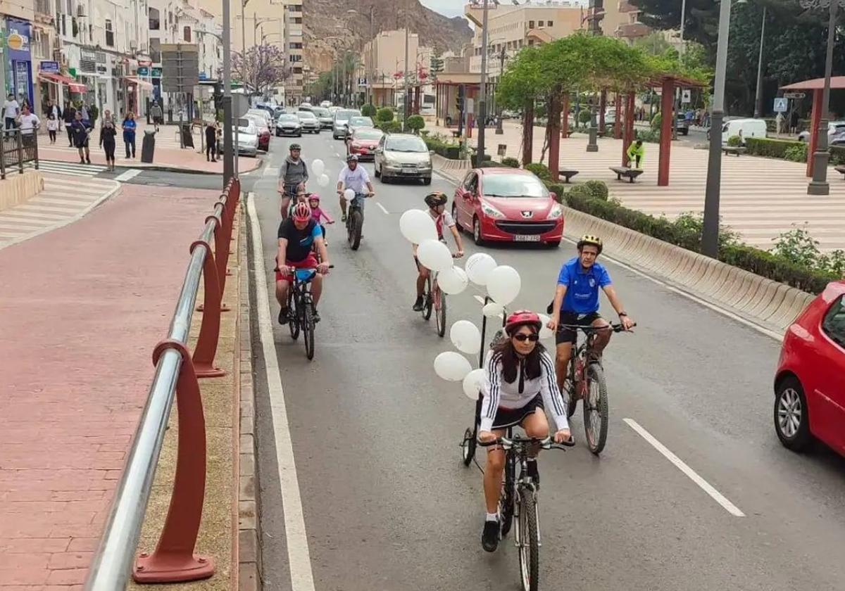 Varios vecinos pasean durante el día en bicicleta por una de las carreteras de Aguadulce.