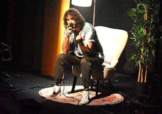 Mikel Izal sentado en un sillón en el escenario.