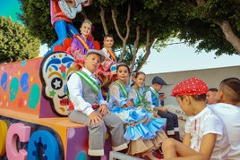 Niños y niñas disfrutando del desfile de carrozas
