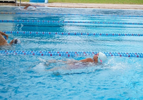 Algunos nadadores realizan ejercicios en la Piscina Municipal de esta localidad.