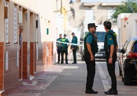 Un vecino se asoma a la puerta en la calle del crimen en La Mojonera.