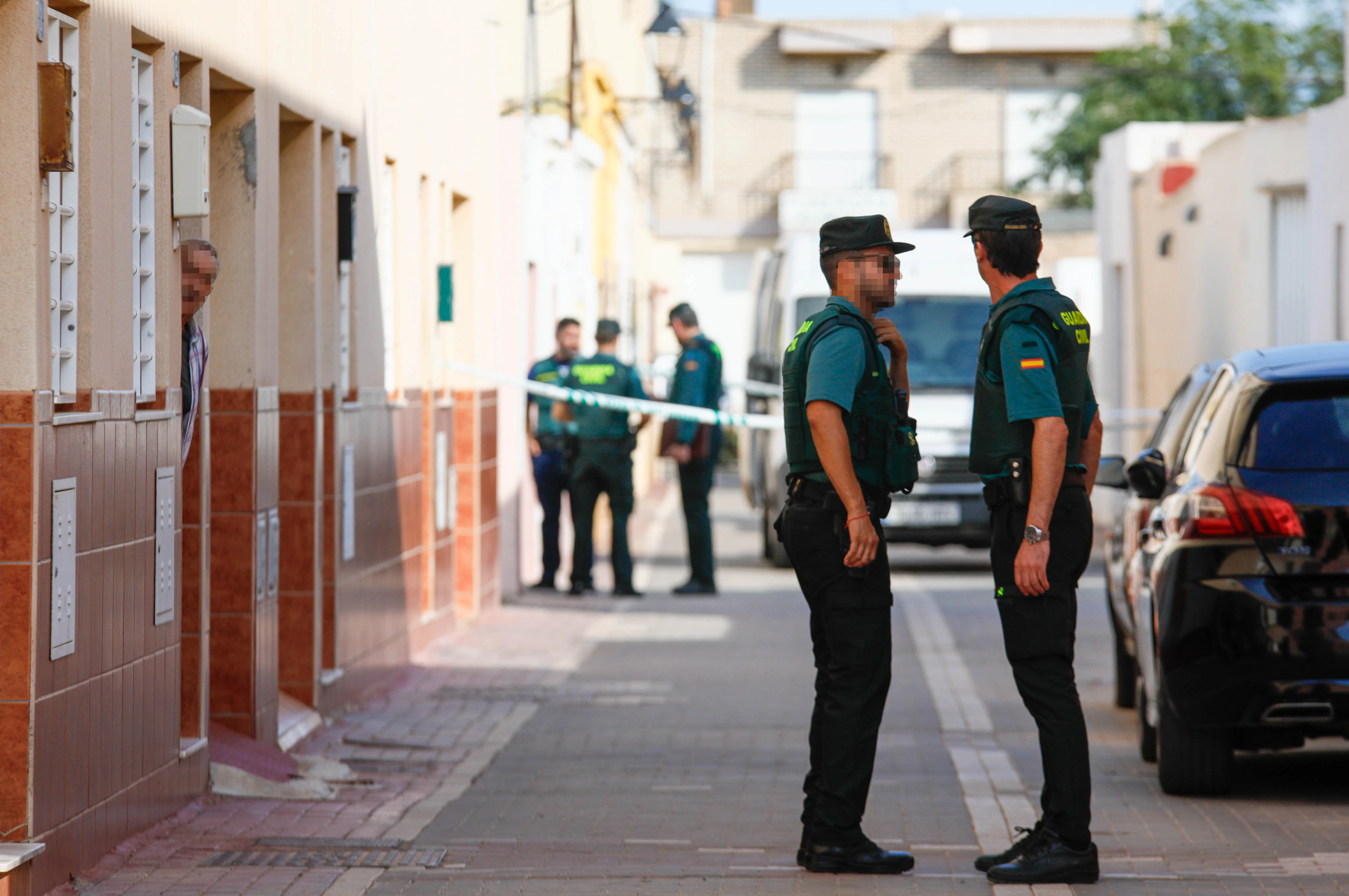 Un vecino se asoma a la puerta en la calle del crimen en La Mojonera.