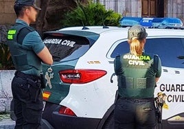 Agentes de Guardia Civil, junto a un vehículo oficial.