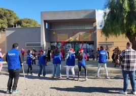 Alumnos y miembros de la asociación bailan al aire libre.