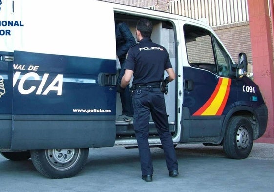 Un agente de Policía Nacional a unos pasos de un vehículo.