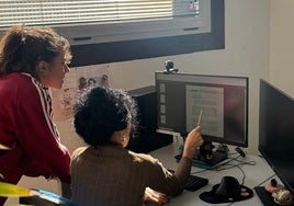 Dos mujeres revisan la información del BOJA.