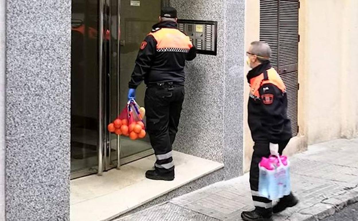 Voluntarios de Protección Civil llevando productos a un domicilio.
