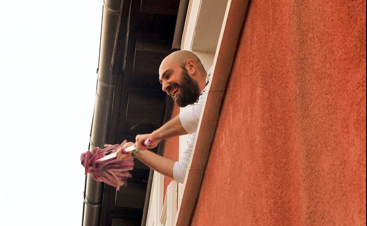 Chema Fuentes agitando su fregona y animando a los vecinos desde la ventana de su piso de Lavapiés.