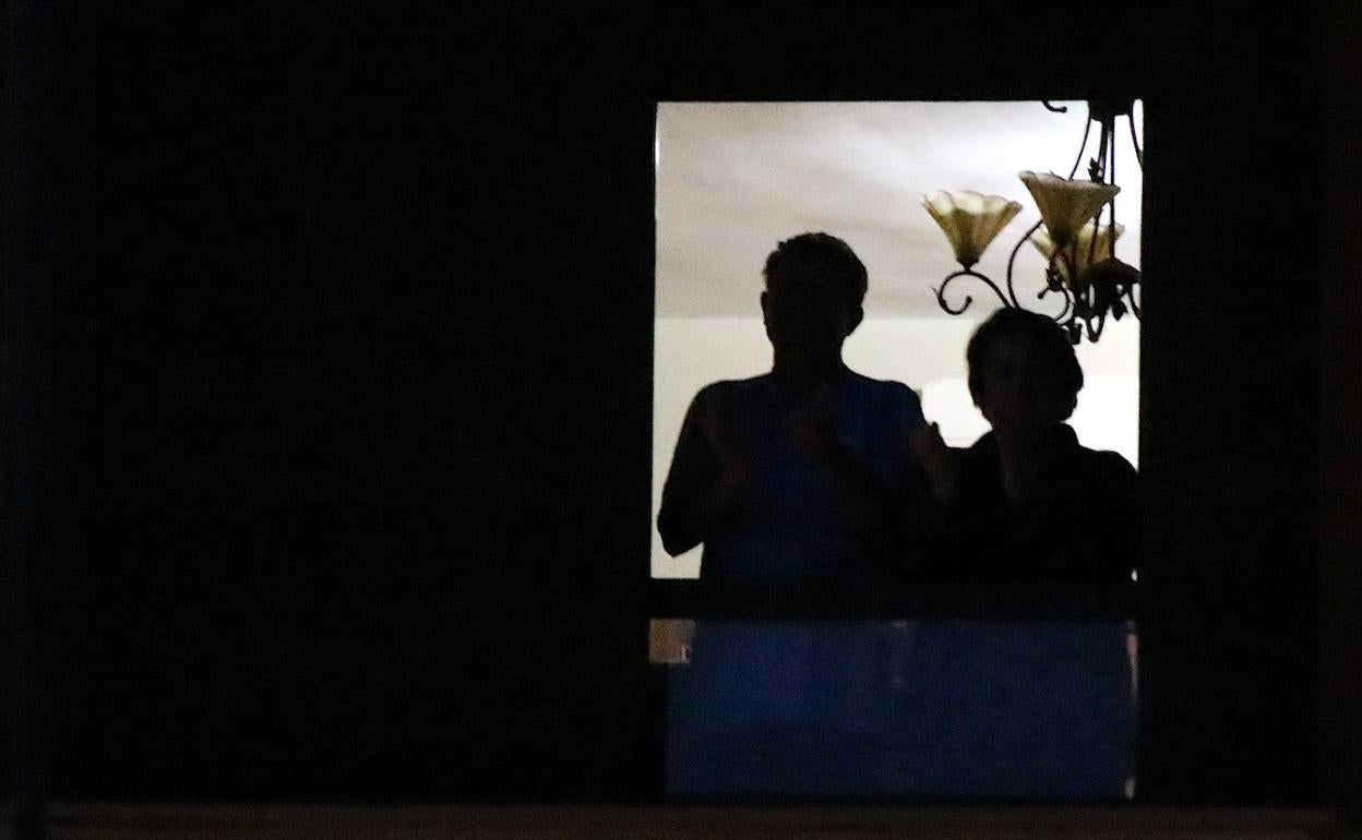 Dos personas en el balcón de su casa.