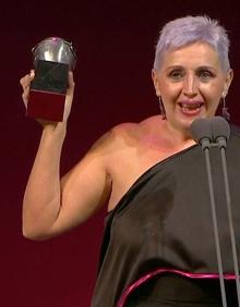 Imagen secundaria 2 - Nati Villar con el premio y los alumnos celebrándolo en la distancia.