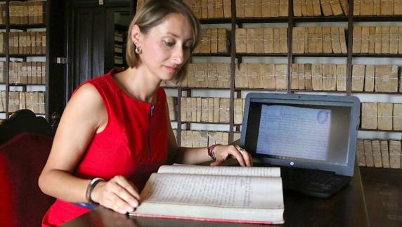 Elena Rodríguez con las actas originales y su versión digitalizada.