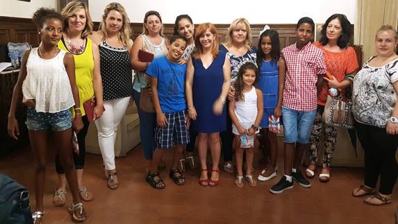 Algunos de los menores y sus familias de acogida con la alcaldesa y la concejal de Bienestar Social.