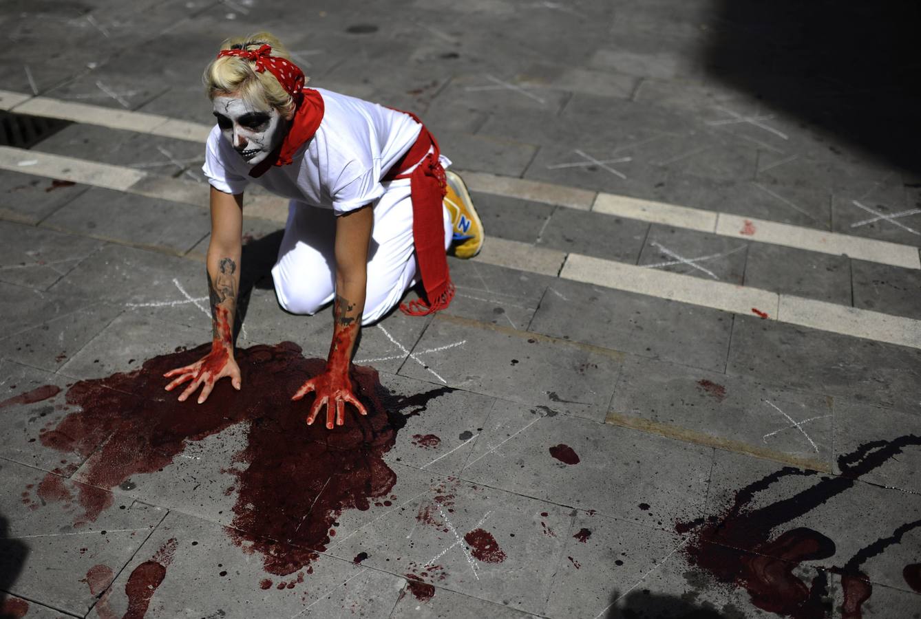Un manifestante anti-taurino lleva el cráneo lleno de maquillaje y una bufanda roja tradicional, en una manifestación frente a Pamplona.
