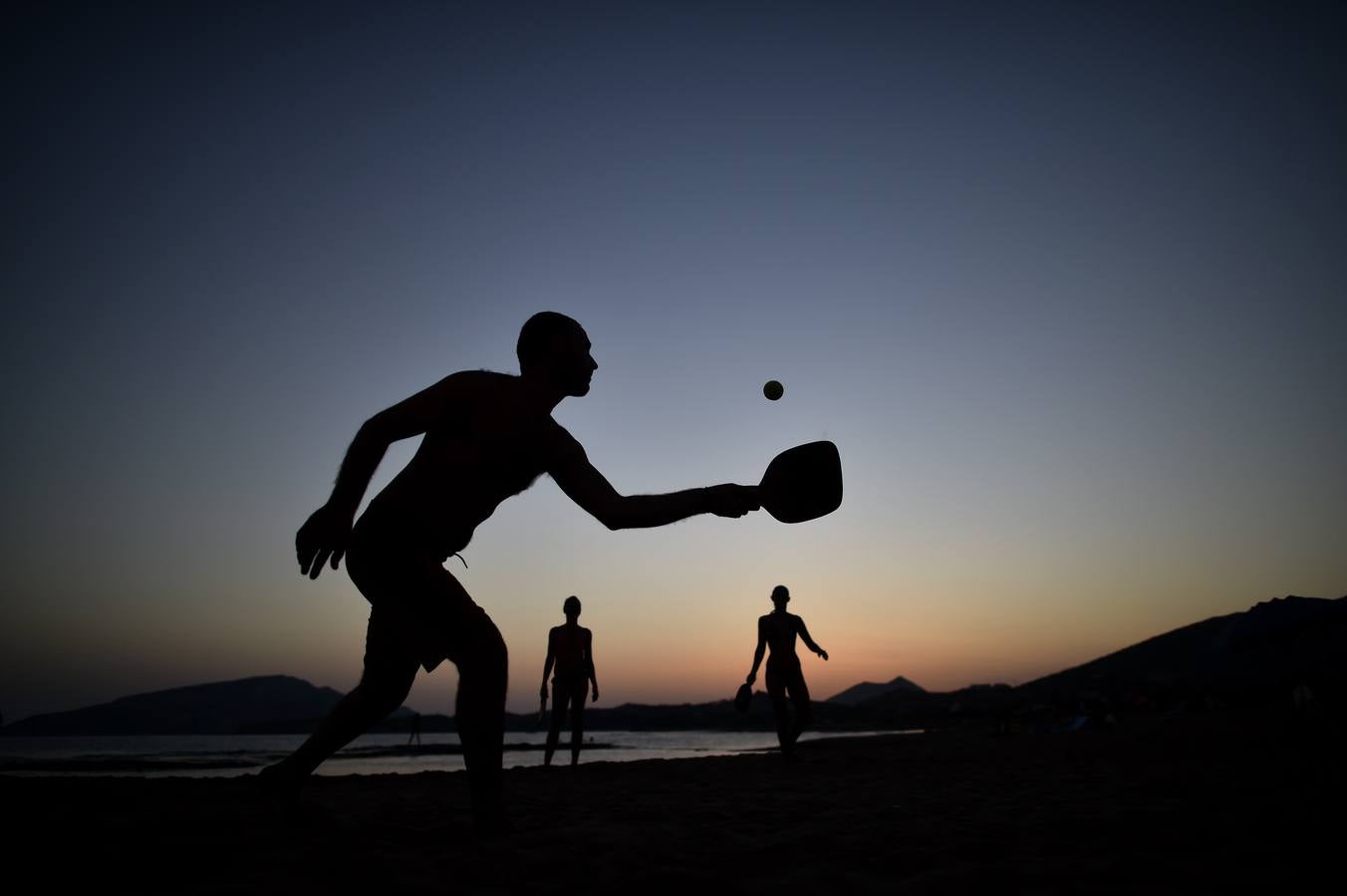 La gente juega ping en la playa de Legrena al sur de Atenas.