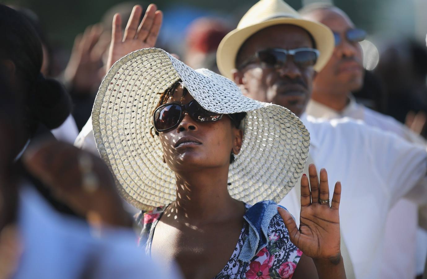 Asistentes levantan la mano, para entrar en el funeral de Michael Brown.