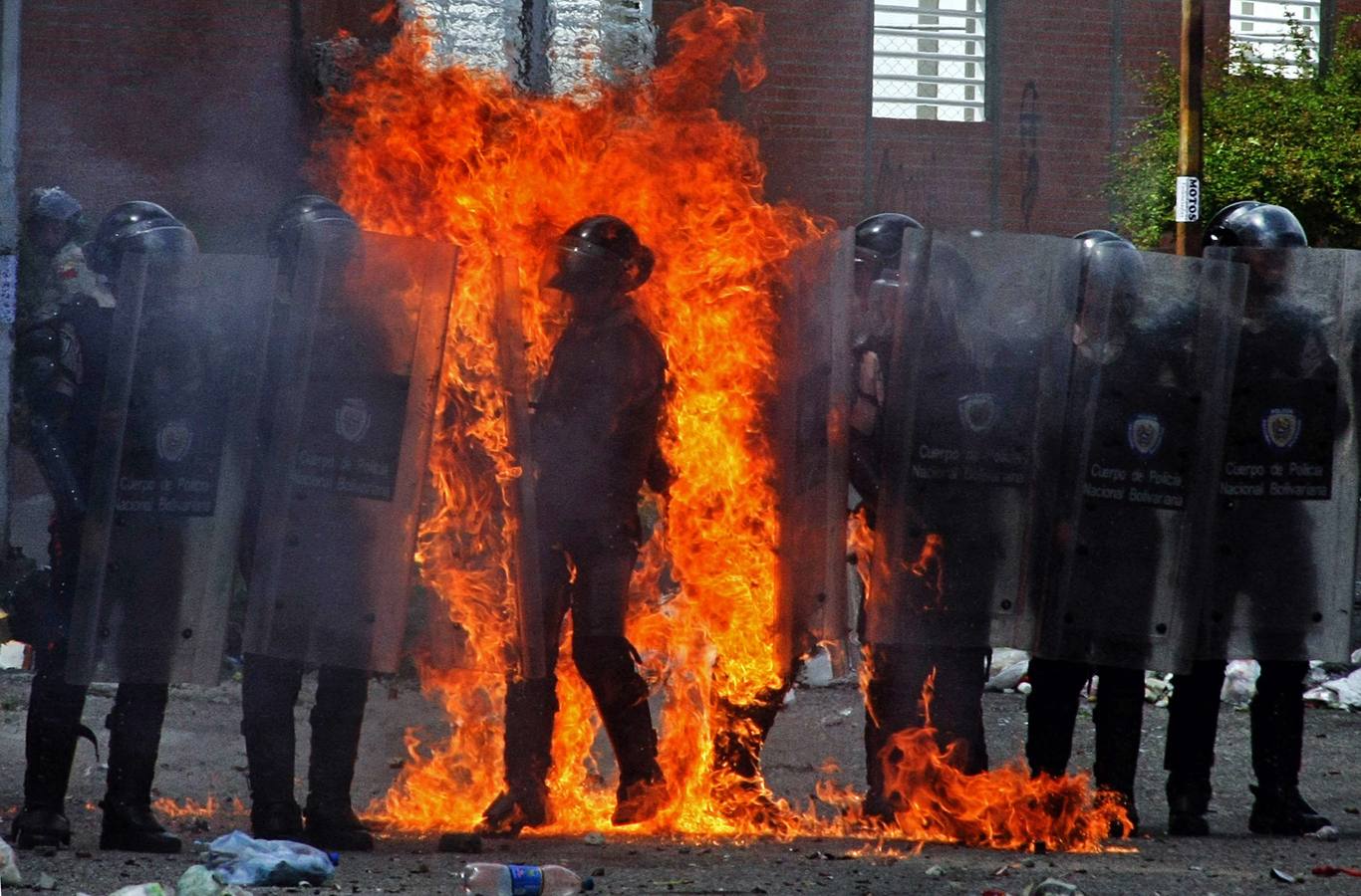 Un policía antidisturbios en llamas por un cóctel molotov lanzado por un pequeño grupo de manifestantes contra el gobierno durante los enfrentamientos en San Cristobal, Venezuela.