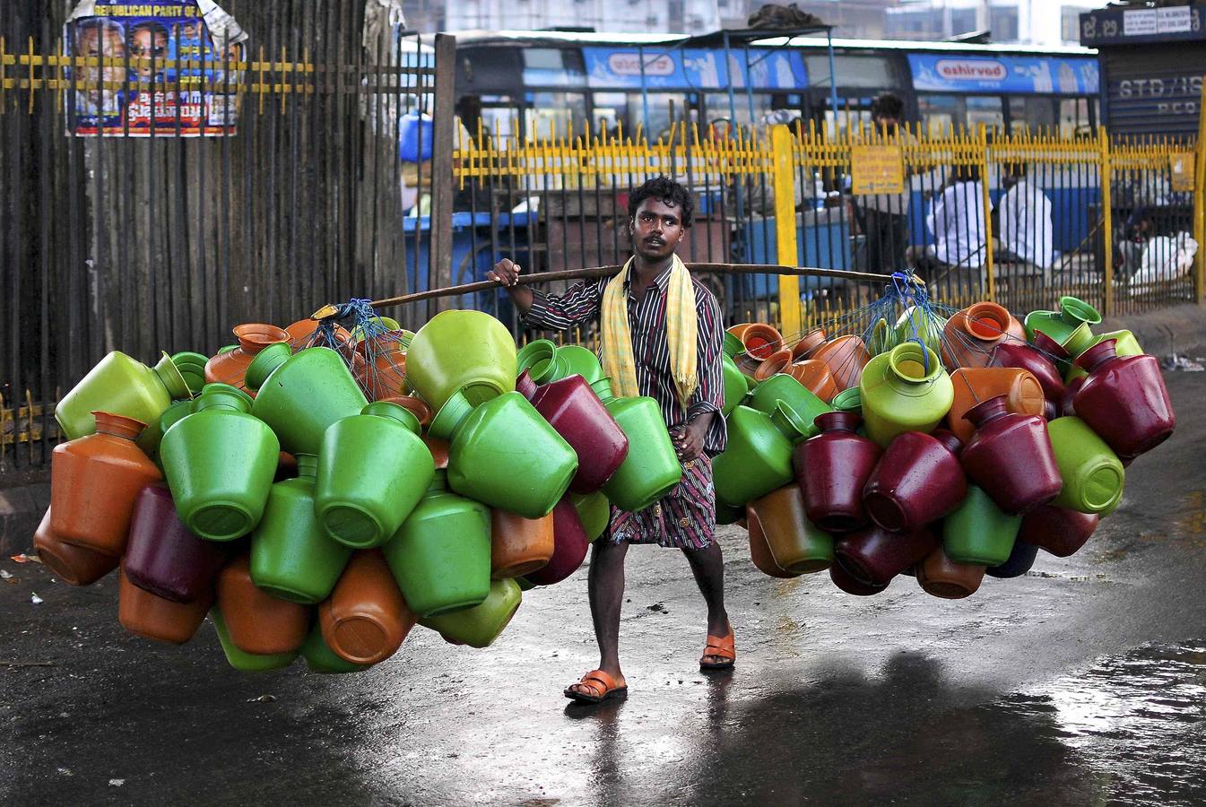 Un hombre lleva jarras de agua vacías para la venta en un mercado en la sureña ciudad india de Bangalore.