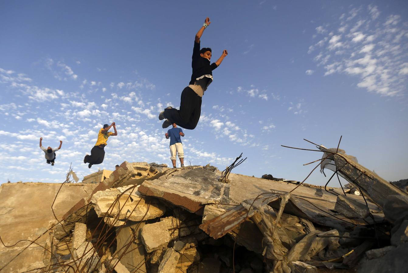Jóvenes palestinos practican sus habilidades de Parkour sobre las ruinas de las casas, que fueron destruidas durante la guerra de Gaza